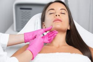 A woman receiving a Botox injection in her chin