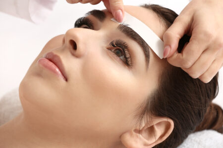 young,woman,undergoing,eyebrow,correction,procedure,in,beauty,salon