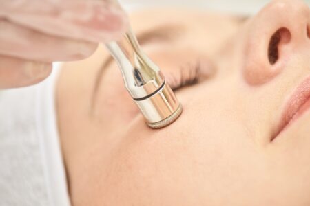 young,caucasian,female,receiving,microdermabrasion,facial,treatment,at,spa,for
